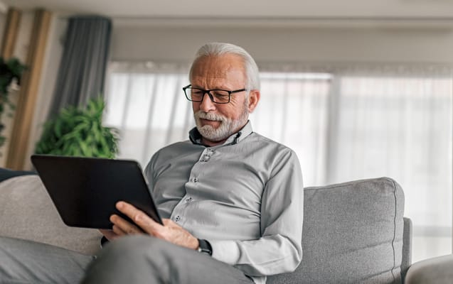 Senior man using a tablet in a comfortable setting