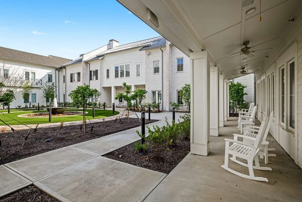 Outdoor courtyard area with rocking chairs and trees