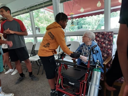 Residents interacting with youth volunteers in an activity room