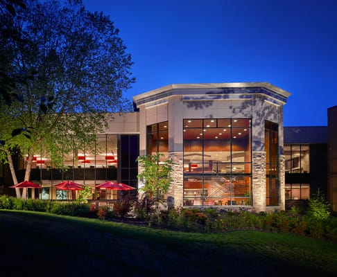 Exterior view of the facility at dusk with outdoor seating