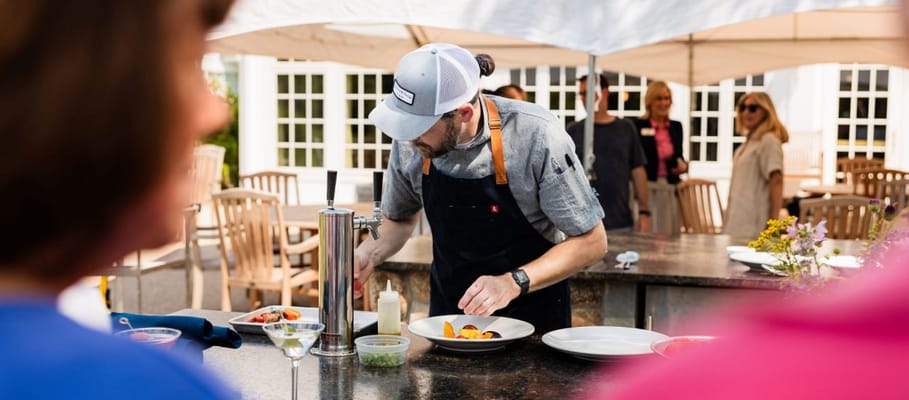 Outdoor cooking event with a chef preparing food