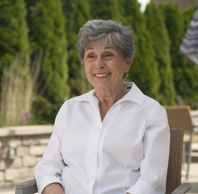 Smiling senior woman sitting outdoors in a casual setting