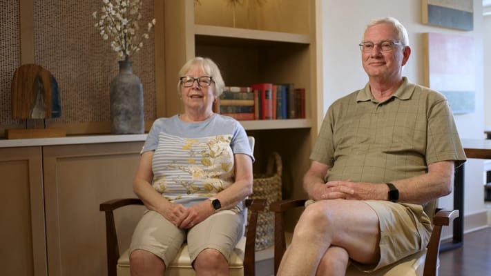 Two residents sitting together in a cozy lounge area
