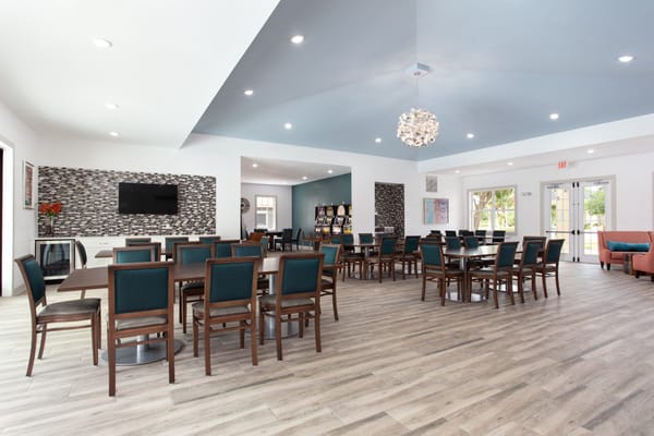 Bright dining room with tables and chairs ready for residents