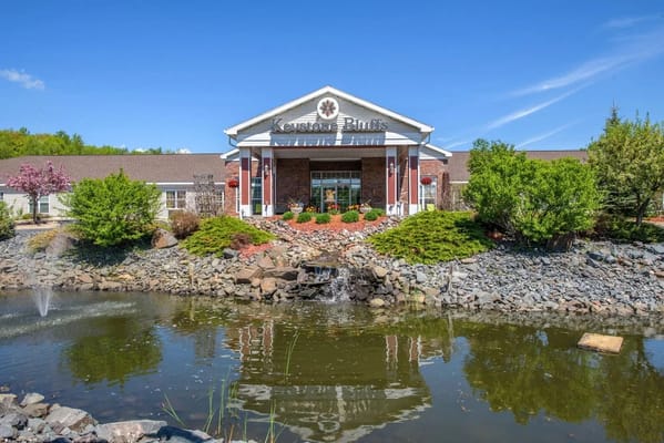 Exterior view of a senior living facility with landscaped pond