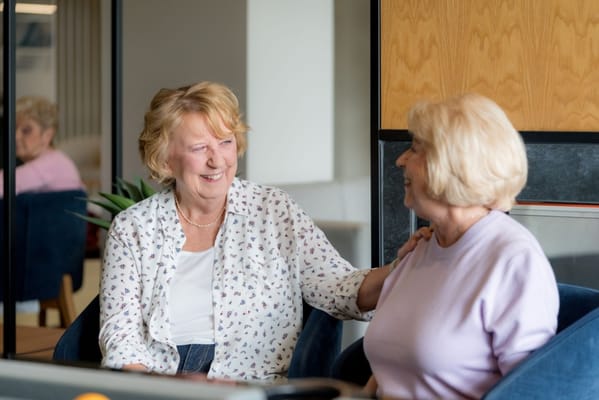 Two residents enjoying a conversation in a common area