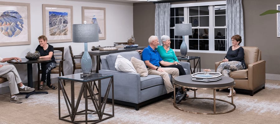 Residents enjoying conversation in a common area lounge