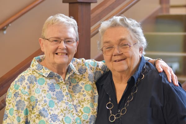 Two residents smiling together in a common area