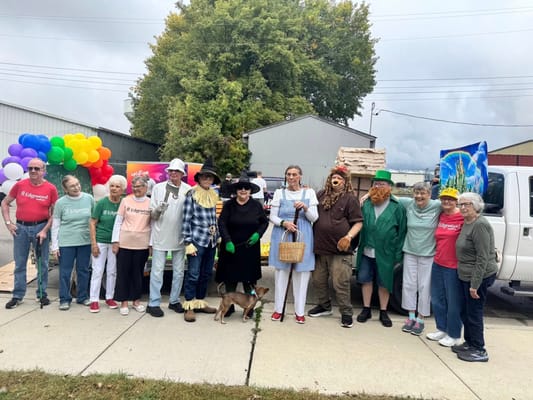 Residents and staff celebrating in costume at an outdoor event
