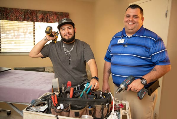 Two maintenance staff posing in a resident room
