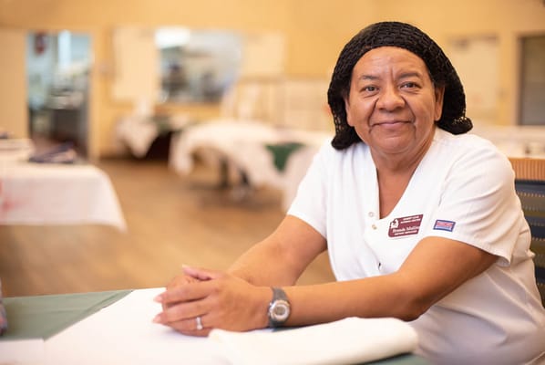 Staff member smiling at a table in the facility