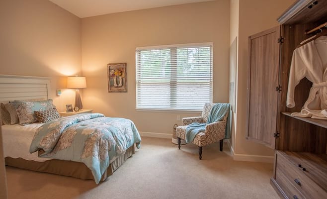 Cozy resident room with a bed and armchair