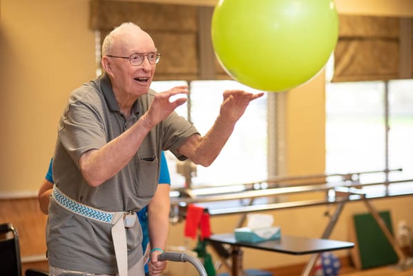 Senior resident engaging in an activity with a large ball
