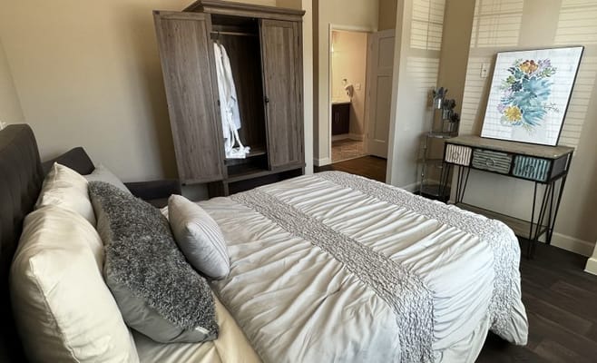 Brightly lit room with a bed and wardrobe