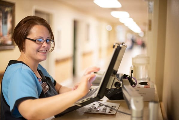 Staff member assisting at a reception area with a tablet