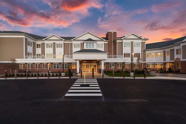 Front exterior of a senior living facility at sunset