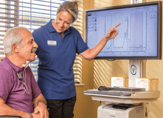 Staff member assisting resident with a display screen