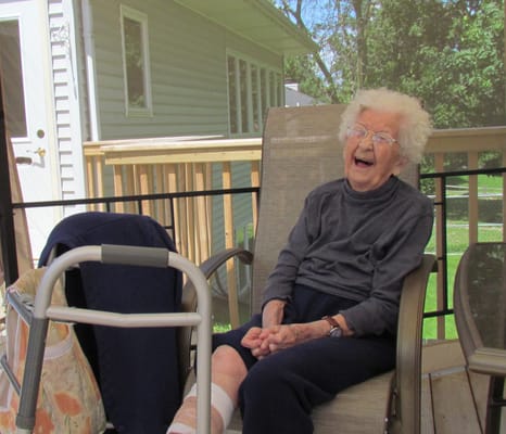 Elderly woman laughing on a patio