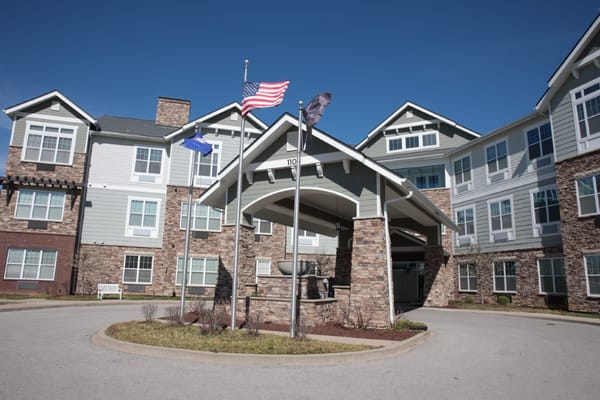 Exterior view of a senior living facility with flags
