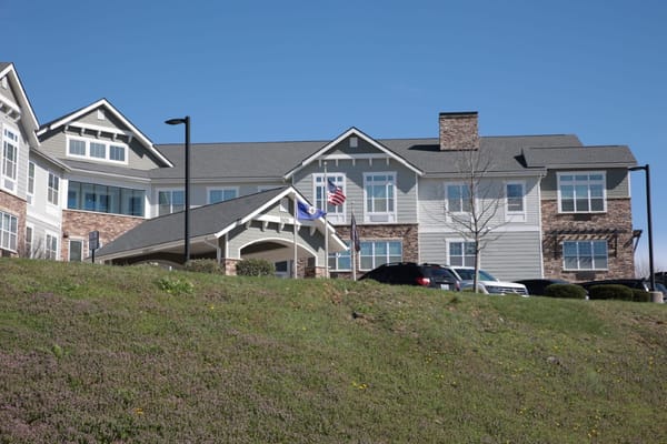 Exterior view of a senior living facility with gardens