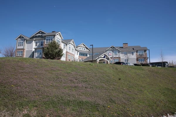 Exterior view of a senior living facility surrounded by green space