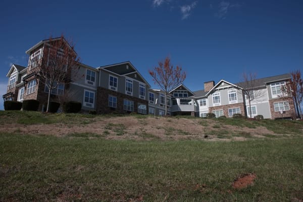 Exterior view of a senior living facility under a blue sky