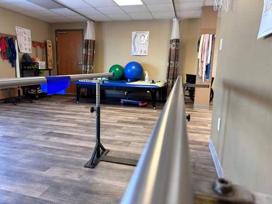 Therapy room with exercise equipment and physical therapy bars