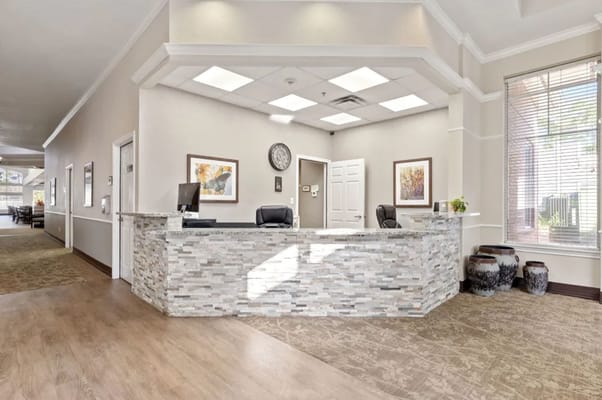 Modern reception area with a stone front desk and artwork on the walls.
