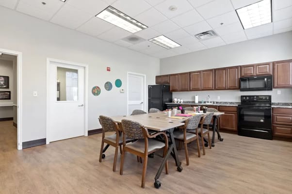 Spacious community room with a table and kitchen