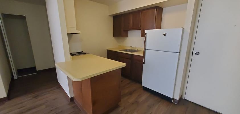 Small kitchen area with refrigerator and counter space