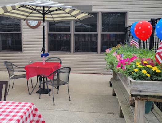Colorful outdoor seating area with a red table and decorative flowers