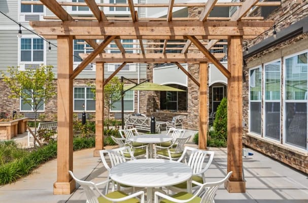Outdoor patio area with tables and greenery