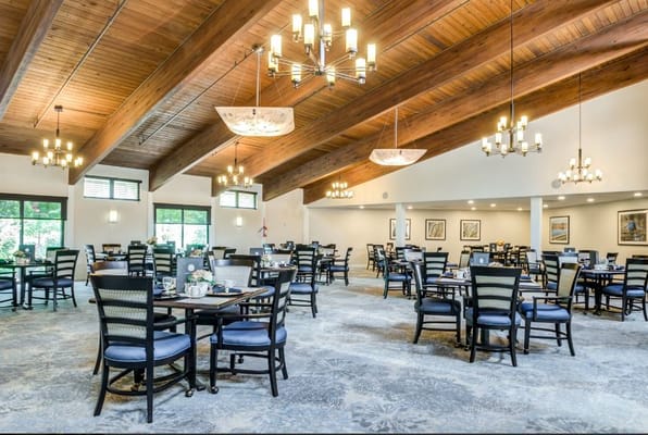 Bright and spacious dining room with tables set for dining