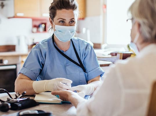 Nurse attending to a resident at a table