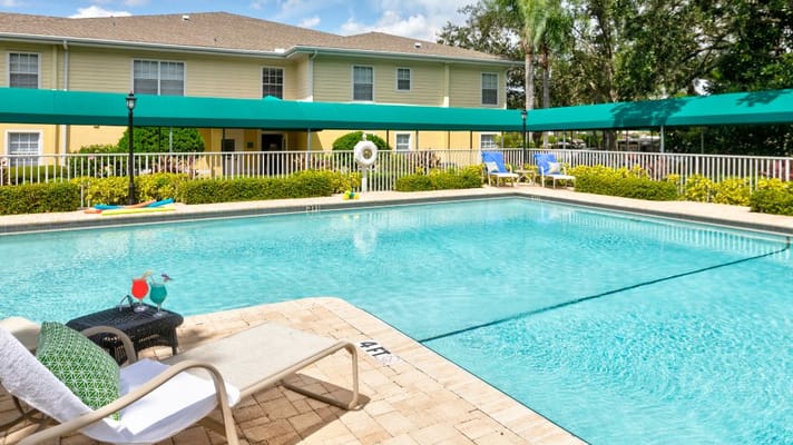 Swimming pool area with lounge chairs and vibrant landscaping