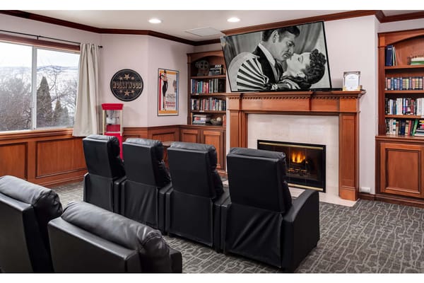Cozy theater room with leather seating and a vintage film on screen.
