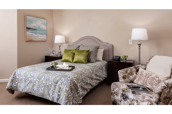 Stylish bedroom with a bed, nightstand, and armchair.
