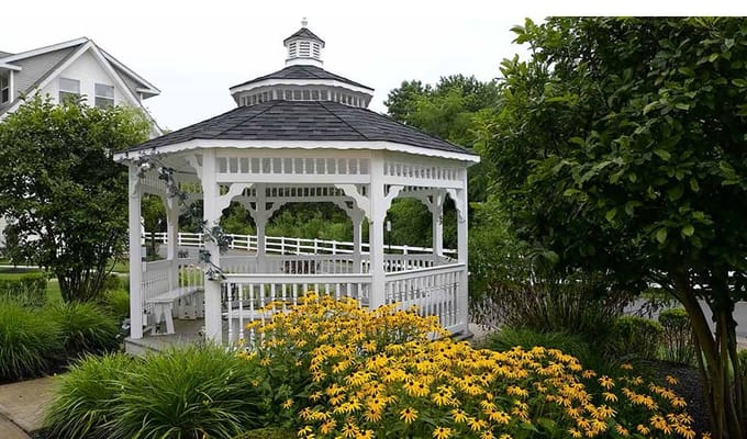 Gazebo surrounded by vibrant flowers in a garden