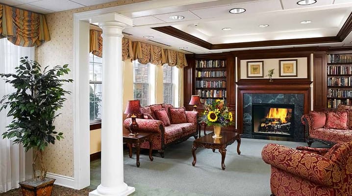Cozy common area with bookshelves and a fireplace