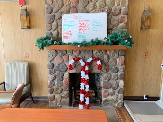 Decorated fireplace in a common area with a gift list