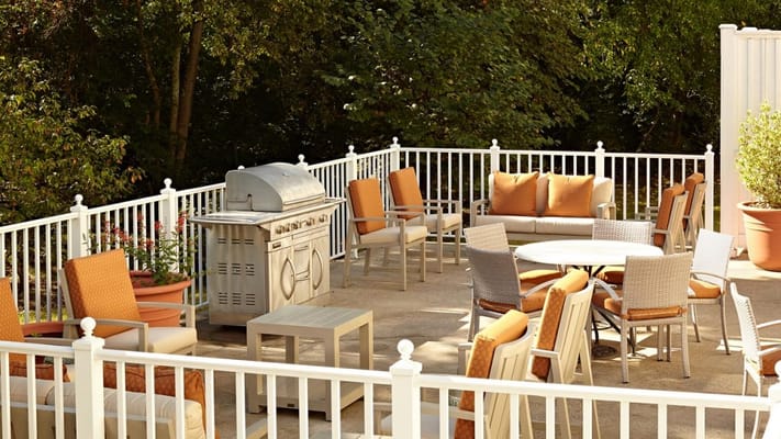 Outdoor seating area with grill in a garden setting