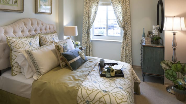 Cozy resident bedroom with decorative bedding and window