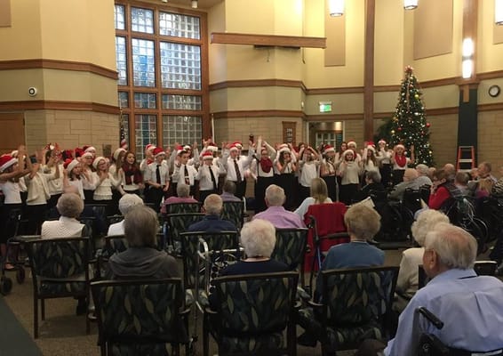 Residents enjoying a holiday performance in the common area