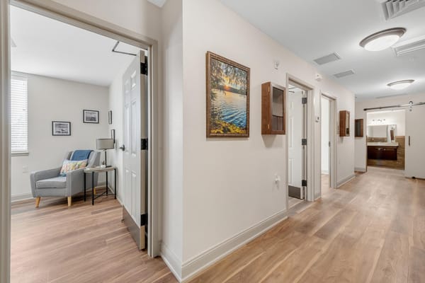 Well-lit corridor leading to a private resident room