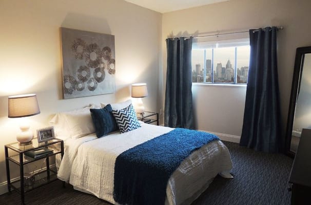 Well-decorated bedroom with a large window and city view