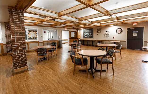 Common area with tables and chairs in a well-lit room