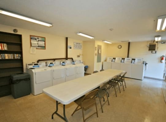 Spacious laundry room with washers, dryers, and a communal table