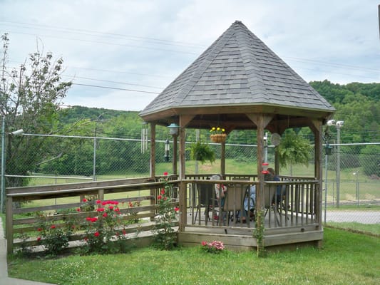 Outdoor gazebo with seating surrounded by greenery