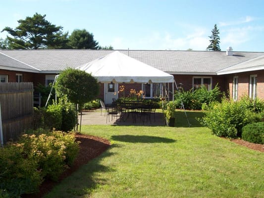 Outdoor area with seating and greenery in a senior living facility