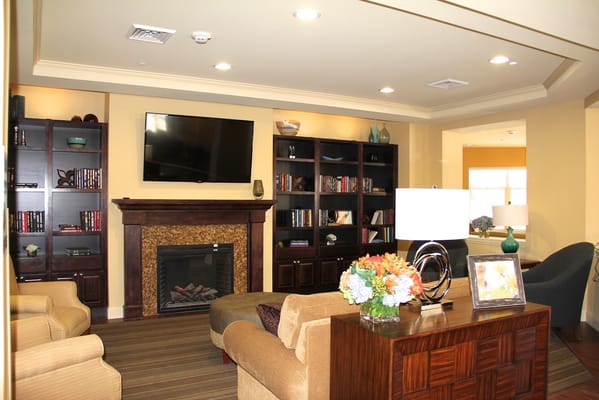 Inviting living room with comfortable seating, bookshelves, and a fireplace